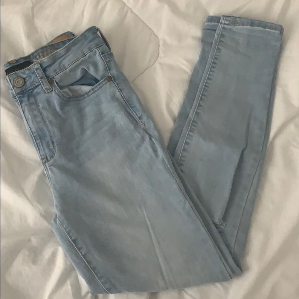 light wash blue skinny jeans with rips in knees